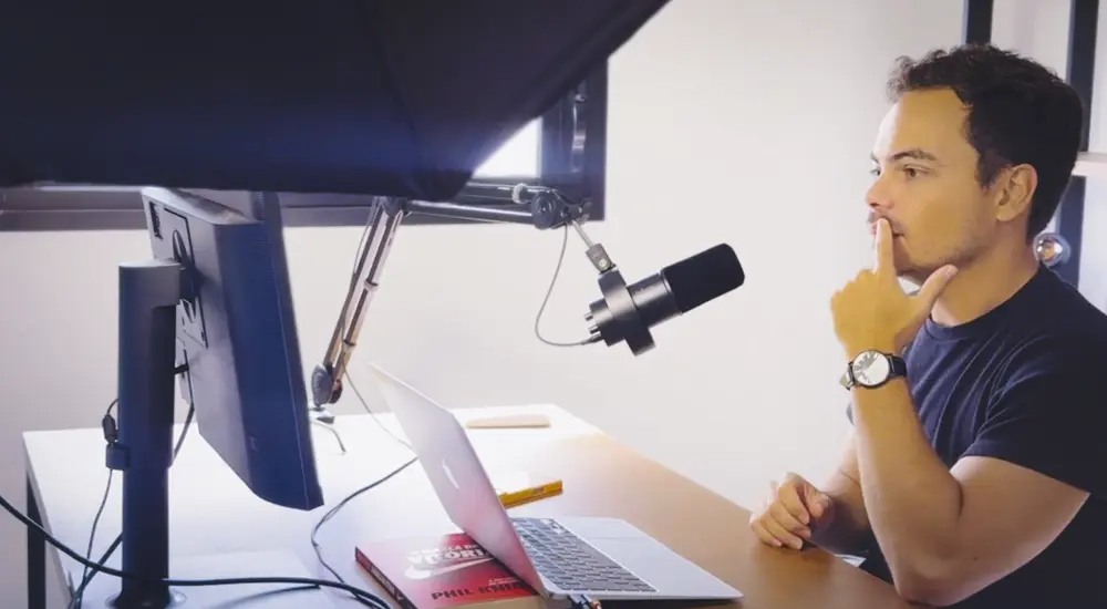Gustavo Bork en su escritorio, entre el monitor, el micrófono y la laptop